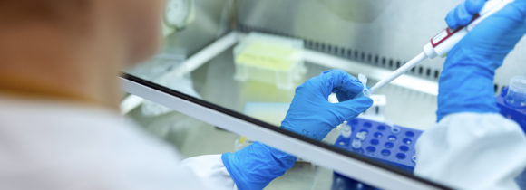 A scientist or research associate using a pipette